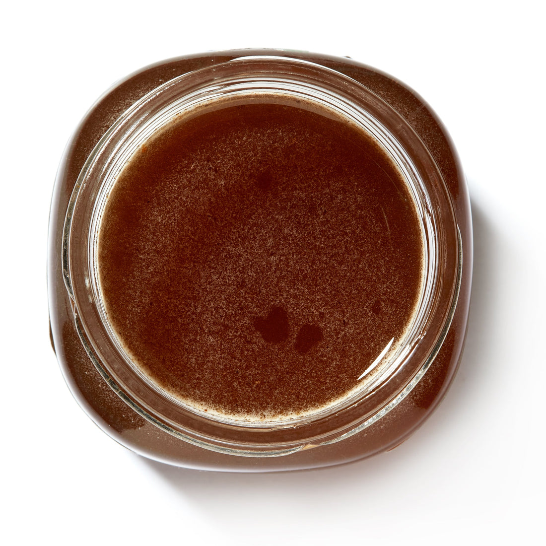 Open jar of Organic Raw Greek Forest Honeydew Honey seen from above